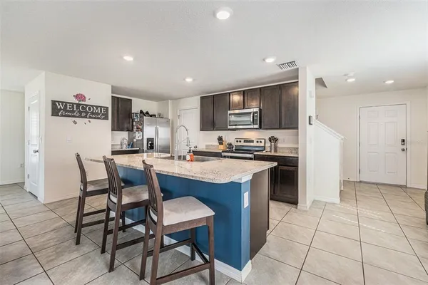 a kitchen with a dining table chairs refrigerator and cabinets
