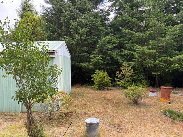 56399 Christopher Road Bandon, OR 97411 - Photo 20 of 34 a view of a backyard with potted plants and large trees