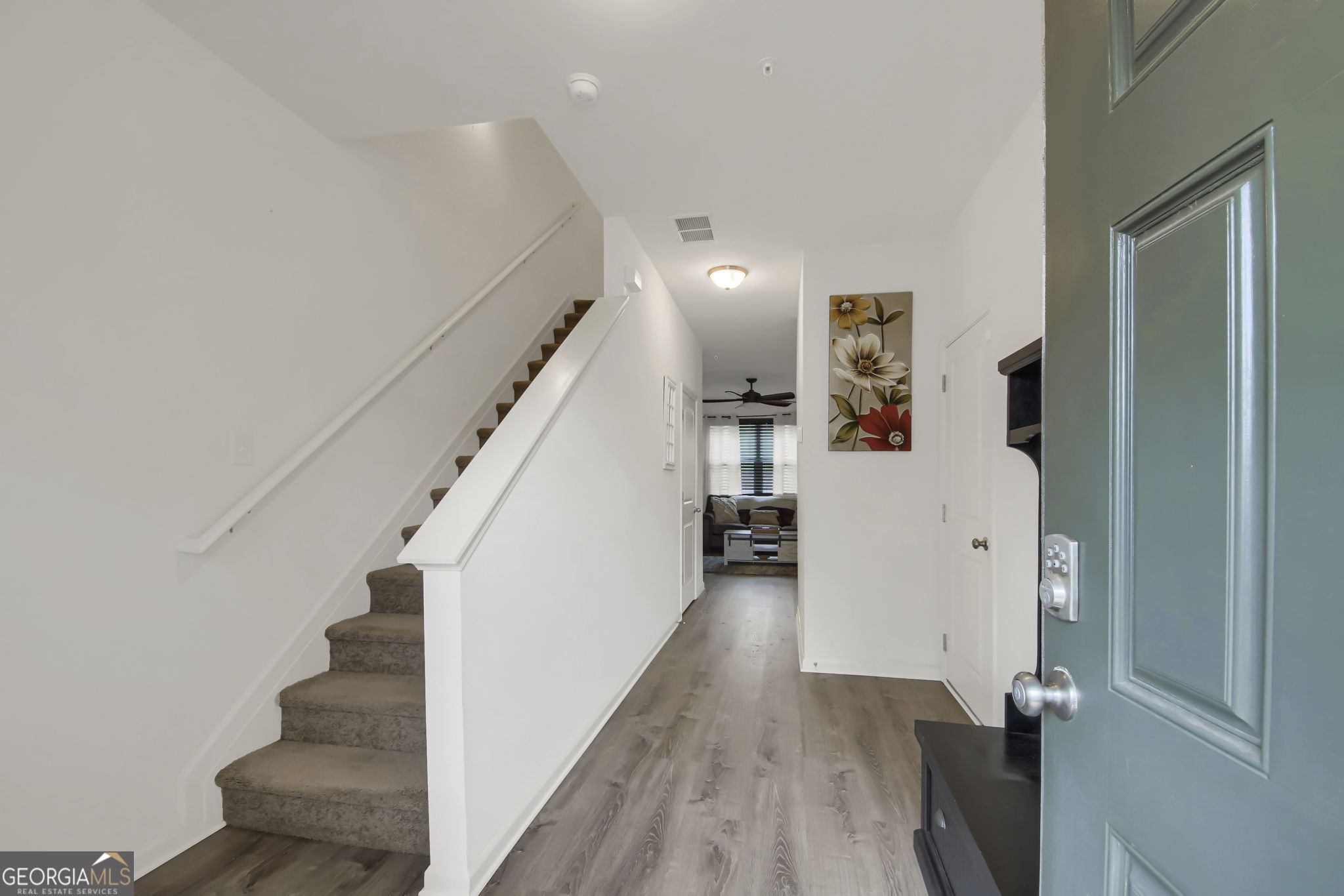 11924 Fuller Street Hampton, GA 30228 - Photo 4 of 26 a view of a hallway with wooden floor and staircase