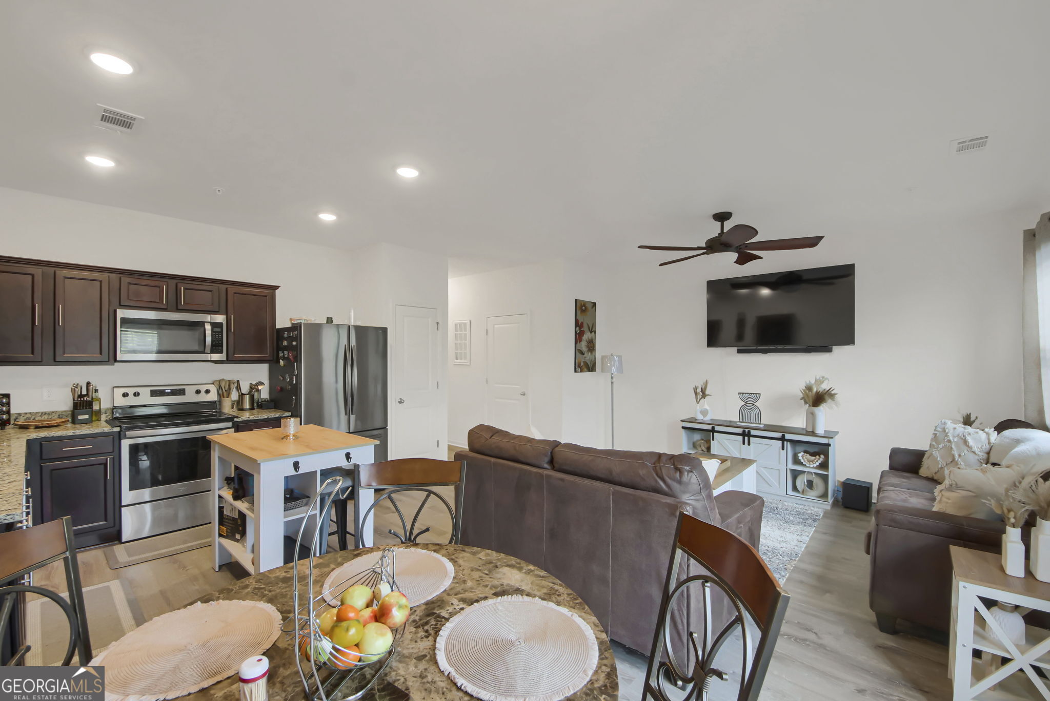 11924 Fuller Street Hampton, GA 30228 - Photo 6 of 26 a living room with stainless steel appliances furniture and a flat screen tv