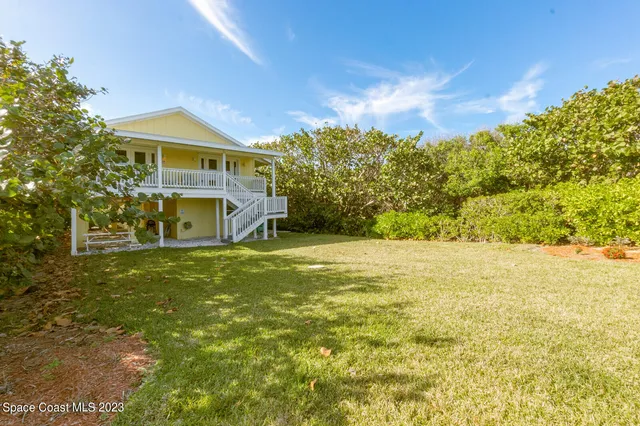 a view of an house with backyard space and balcony