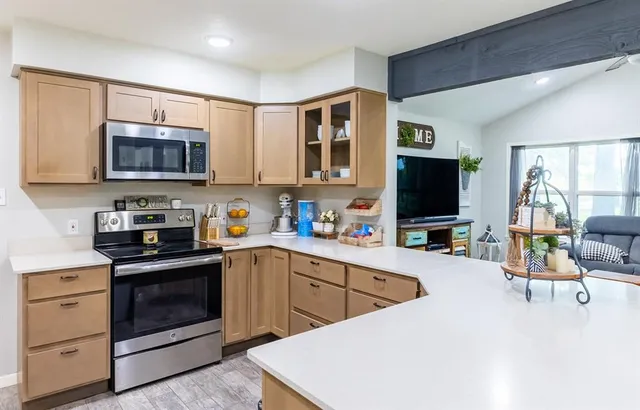 a kitchen with stainless steel appliances a stove sink microwave and cabinets