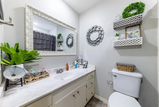a bathroom with a toilet a sink and a mirror