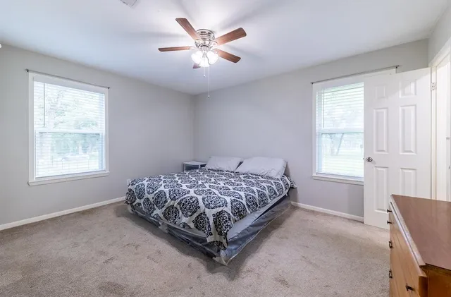 a bed sitting in a bedroom next to a window