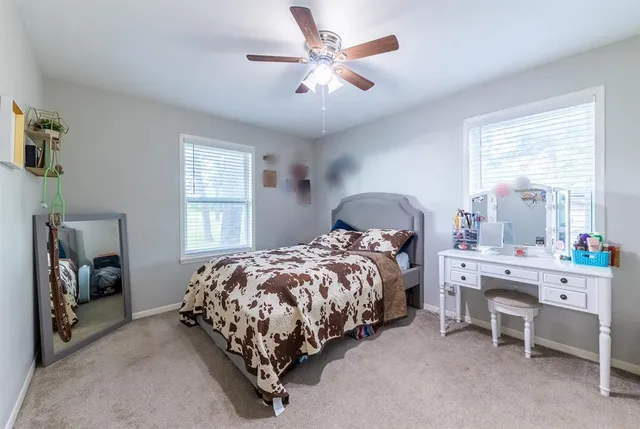 a bedroom with a bed and a chandelier fan