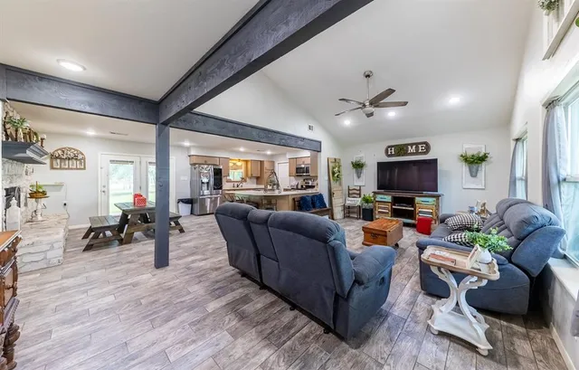 a living room with furniture a flat screen tv and a large window