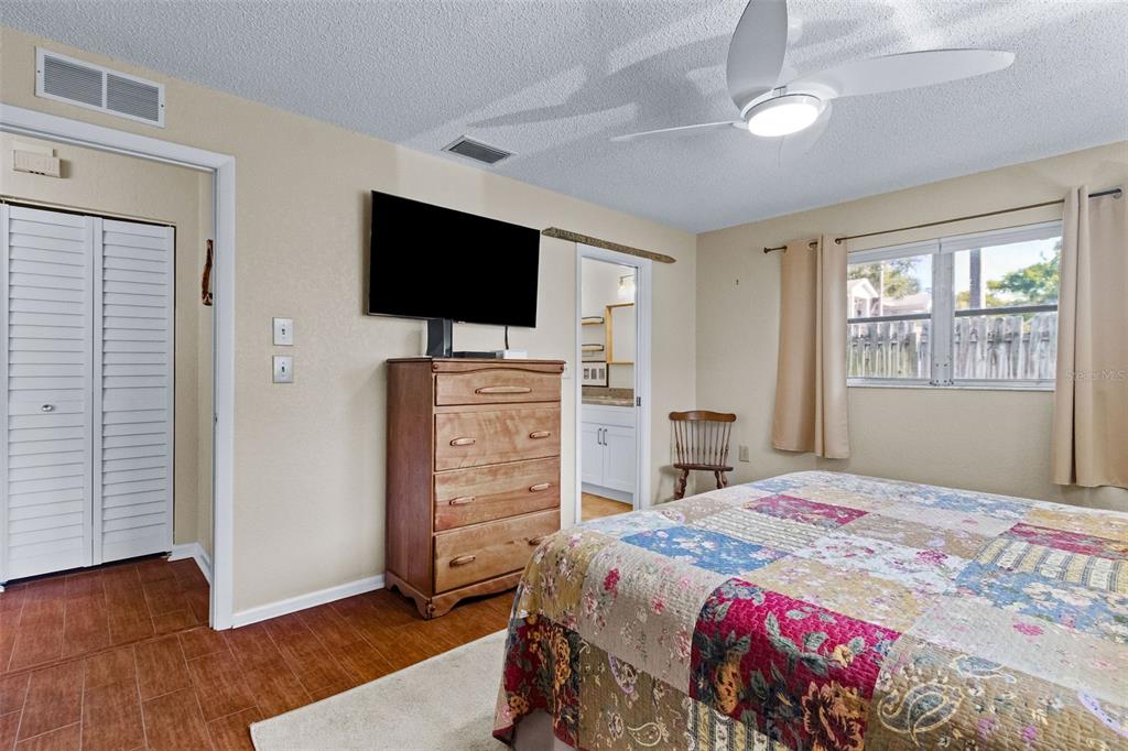 1417 Heather Ridge Boulevard Dunedin, FL 34698 - Photo 14 of 37 a bedroom with a bed and a flat screen tv