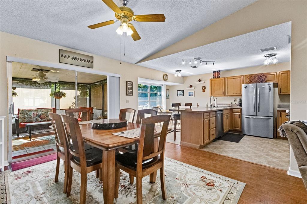 1417 Heather Ridge Boulevard Dunedin, FL 34698 - Photo 6 of 37 a dining room with stainless steel appliances kitchen island granite countertop a dining table and chairs