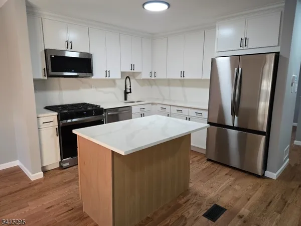 a kitchen with stainless steel appliances a refrigerator stove and microwave