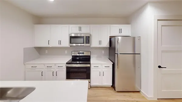 a kitchen with stainless steel appliances a refrigerator stove and microwave