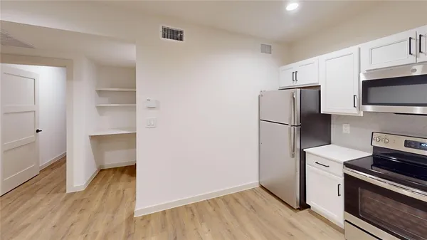 a kitchen with a refrigerator and a stove top oven