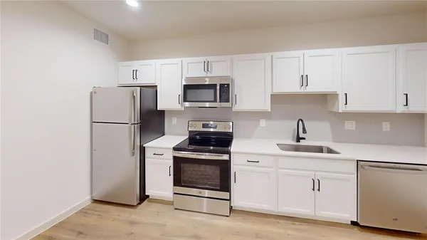 a kitchen with white cabinets and stainless steel appliances
