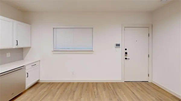 a view of a room with wooden floor and white walls