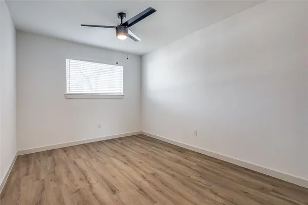 an empty room with a window and a ceiling fan