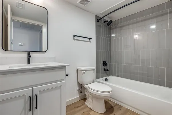a bathroom with a toilet sink vanity tub and shower