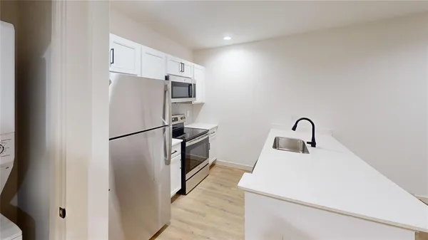 a kitchen with refrigerator a sink and cabinets