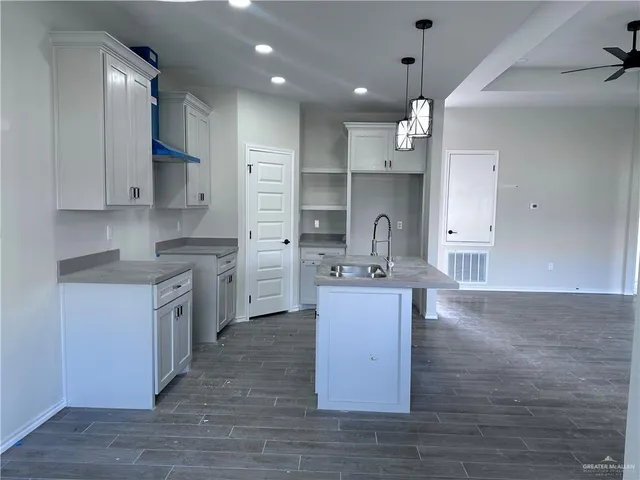 a kitchen with kitchen island a sink appliances and cabinets