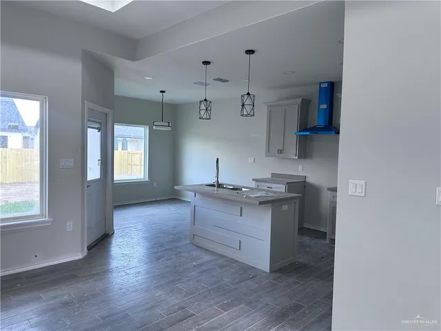 a kitchen with a sink cabinets and wooden floor