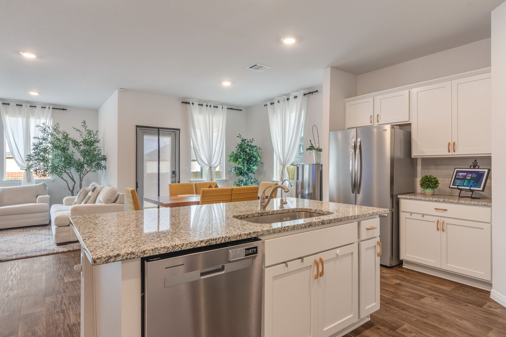 205 Charles Trail Georgetown, TX 78626 - Photo 34 of 36 Kitchen featuring open floor plan, stainless steel appliances, white cabinets, dark wood-type flooring, and light stone counters