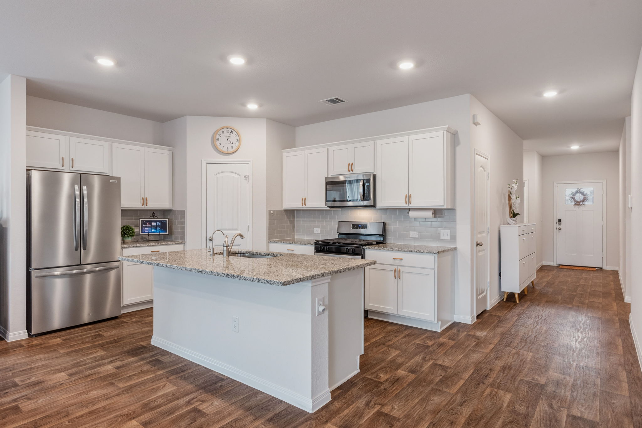 205 Charles Trail Georgetown, TX 78626 - Photo 12 of 36 Kitchen featuring stainless steel appliances, white cabinets, dark wood-style flooring, light stone countertops, and recessed lighting
