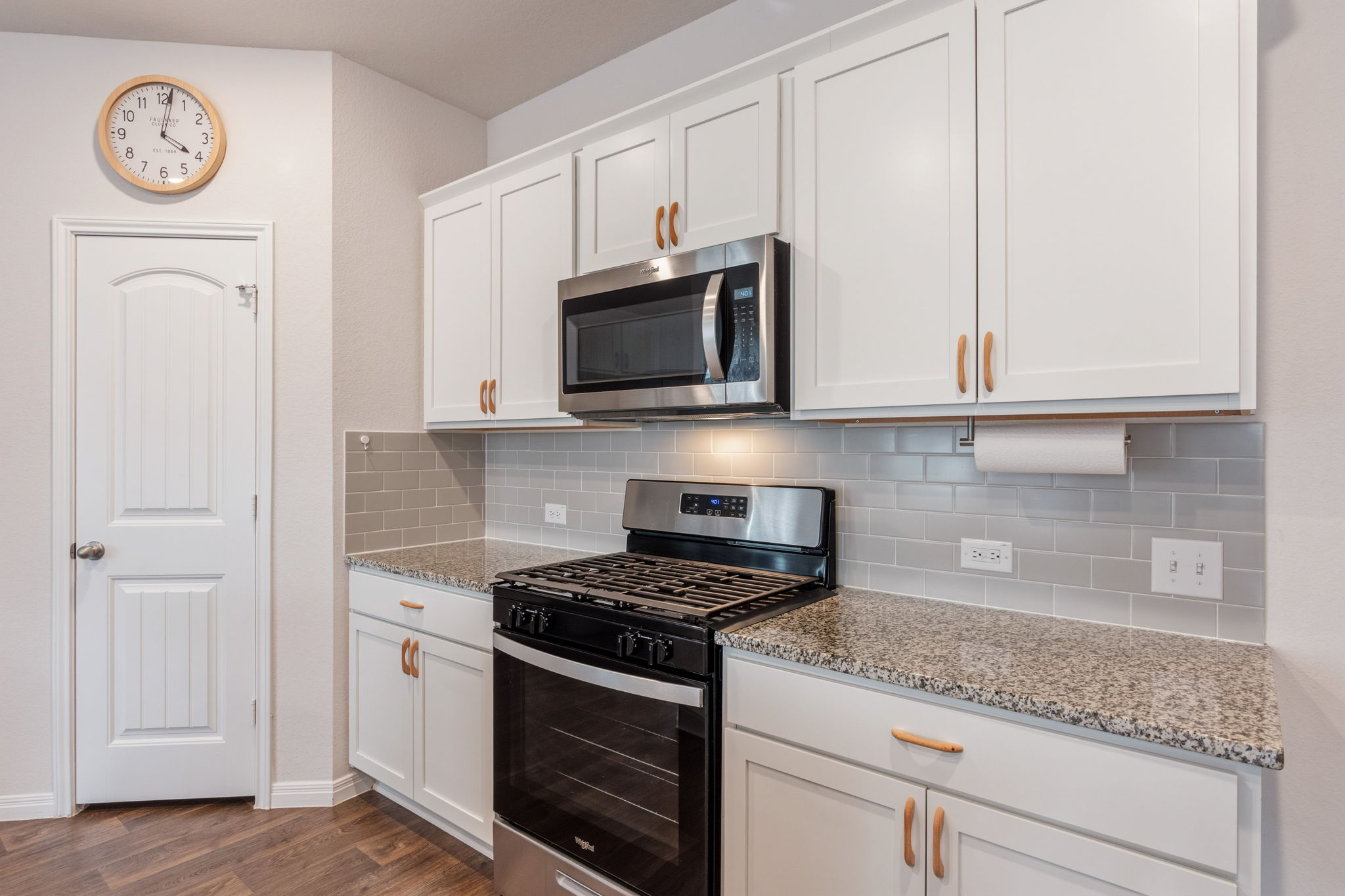 205 Charles Trail Georgetown, TX 78626 - Photo 13 of 36 Kitchen with stainless steel appliances, white cabinets, light stone counters, backsplash, and dark wood-style floors