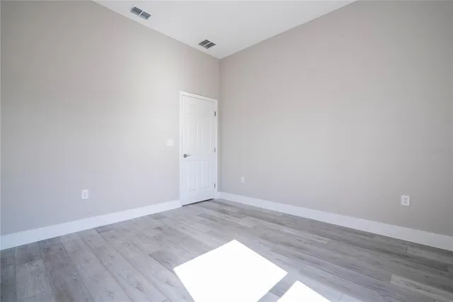 an empty room with wooden floor and closet