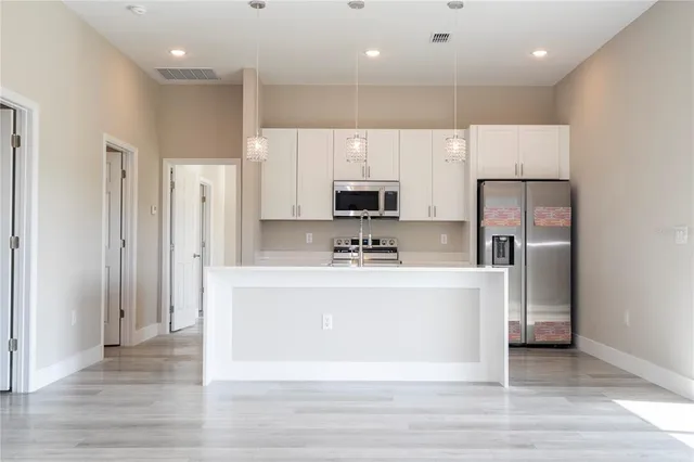 a view of kitchen with granite countertop window and refrigerator