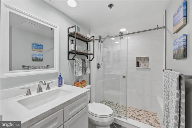 a bathroom with a sink toilet vanity and shower