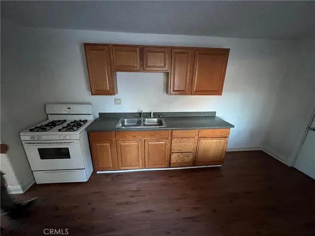 a kitchen with granite countertop wooden cabinets and a stove top oven