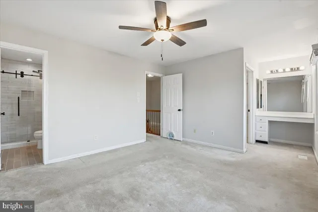 a view of an empty room with a ceiling fan
