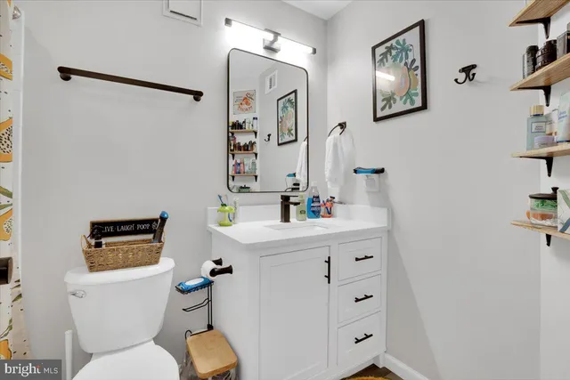 a bathroom with a sink mirror vanity and toilet