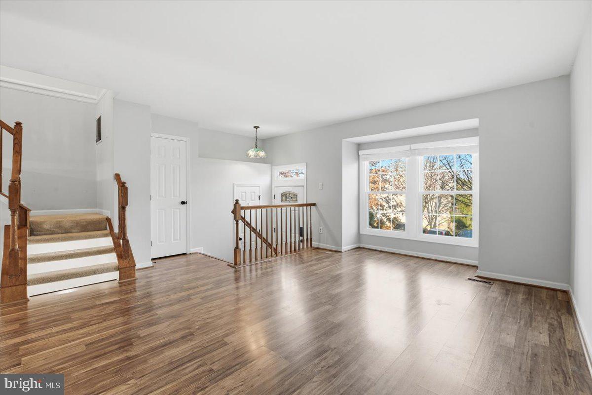 10700 Winfield Loop Manassas, VA 20109 - Photo 4 of 31 a view of an empty room with wooden floor and a window
