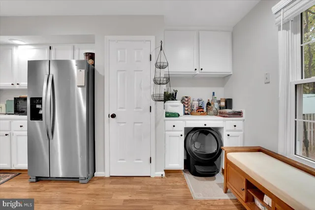 a kitchen with stainless steel appliances granite countertop a refrigerator a washer and dryer