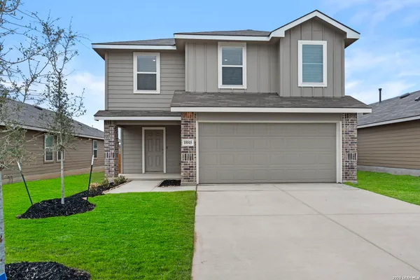 a front view of a house with a garden and yard