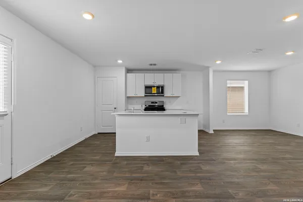 a view of kitchen with granite top and white stainless steel appliances
