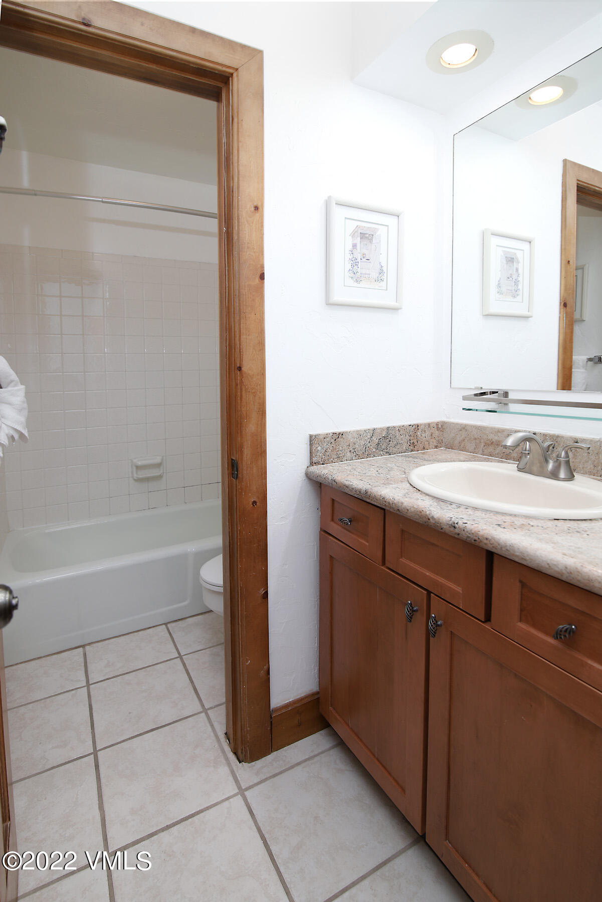 548 South Frontage Road West, Unit 105 Vail, CO 81657 - Photo 12 of 19 a bathroom with a granite countertop sink a mirror and a bathtub