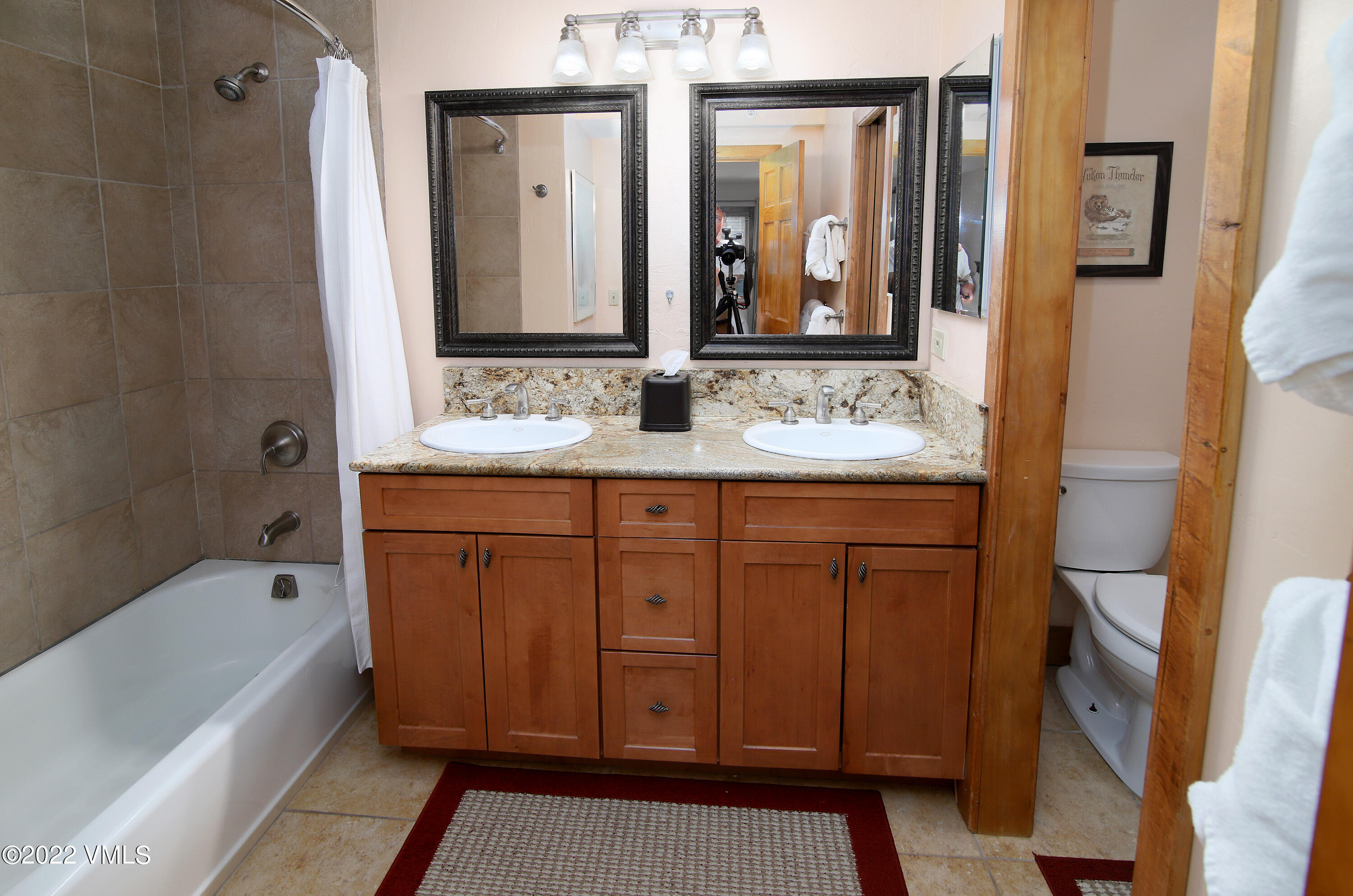 548 South Frontage Road West, Unit 105 Vail, CO 81657 - Photo 10 of 19 a bathroom with a double vanity sink a mirror a bathtub and shower