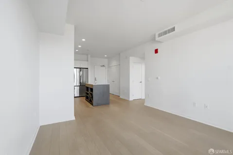 an empty room with a fireplace and wooden floor