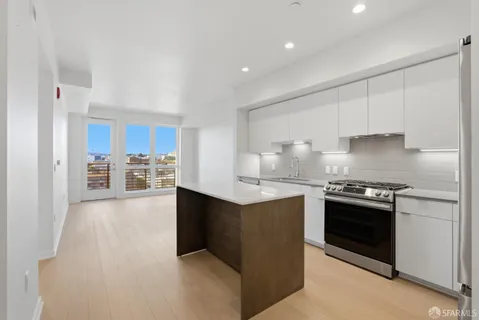a kitchen with granite countertop a refrigerator stove and sink