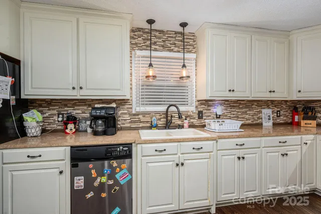 a kitchen with stainless steel appliances granite countertop a sink a stove and cabinets