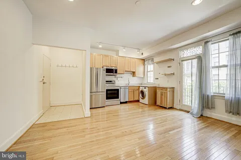 a large kitchen with stainless steel appliances a refrigerator and a stove top oven