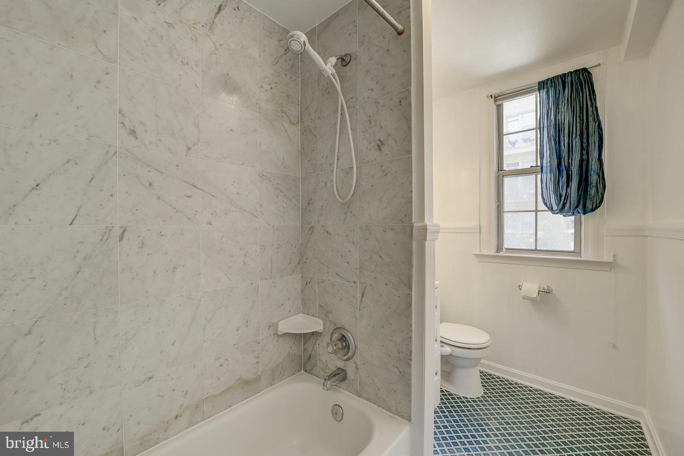 1401 Columbia Road Northwest, Unit 219 Washington, DC 20009 - Photo 15 of 33 a bathroom with a shower a toilet and a window