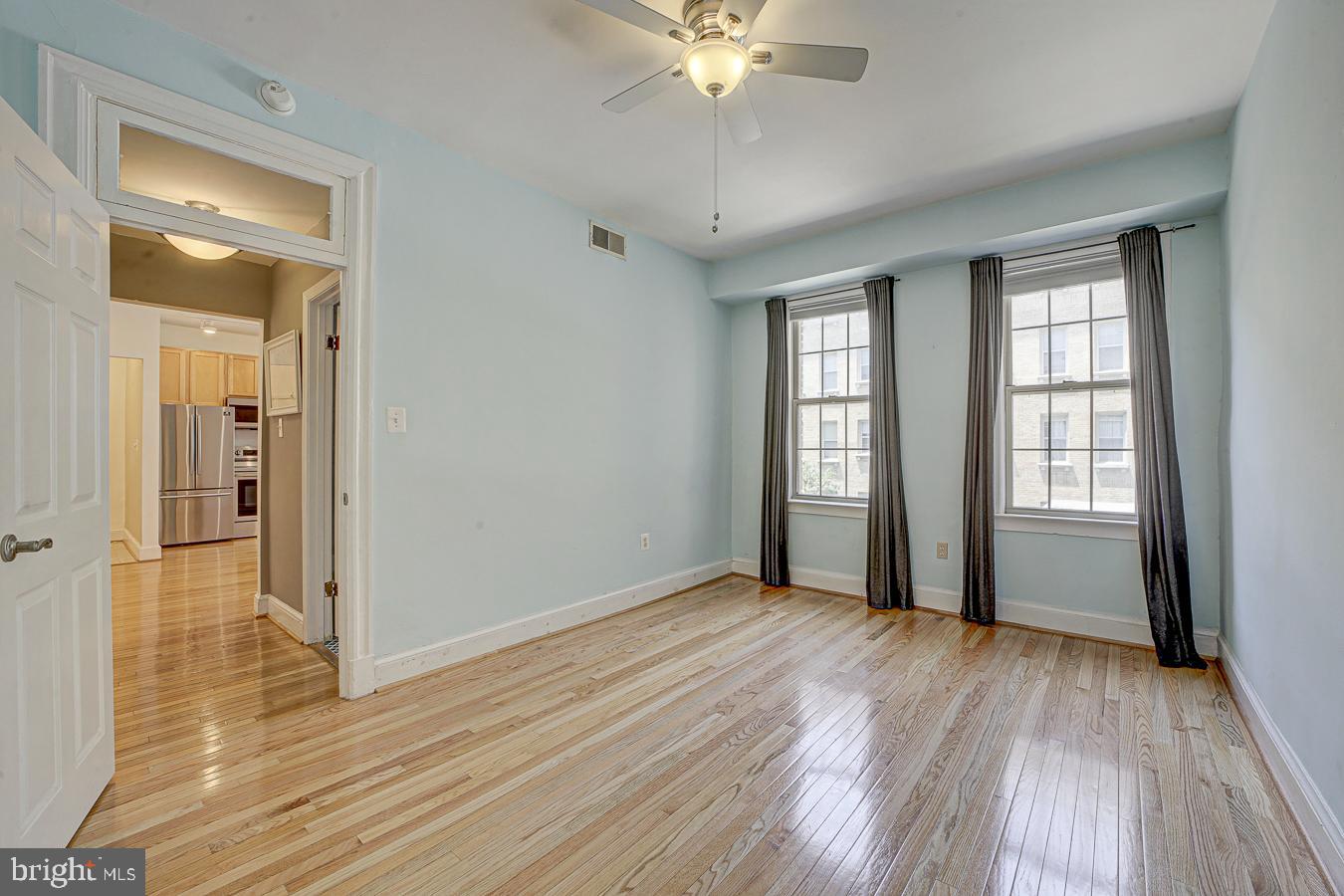 1401 Columbia Road Northwest, Unit 219 Washington, DC 20009 - Photo 17 of 33 a view of an empty room with wooden floor and a window