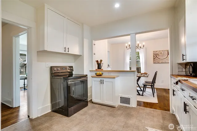 a kitchen with stainless steel appliances granite countertop a stove top oven a sink a refrigerator and white cabinets