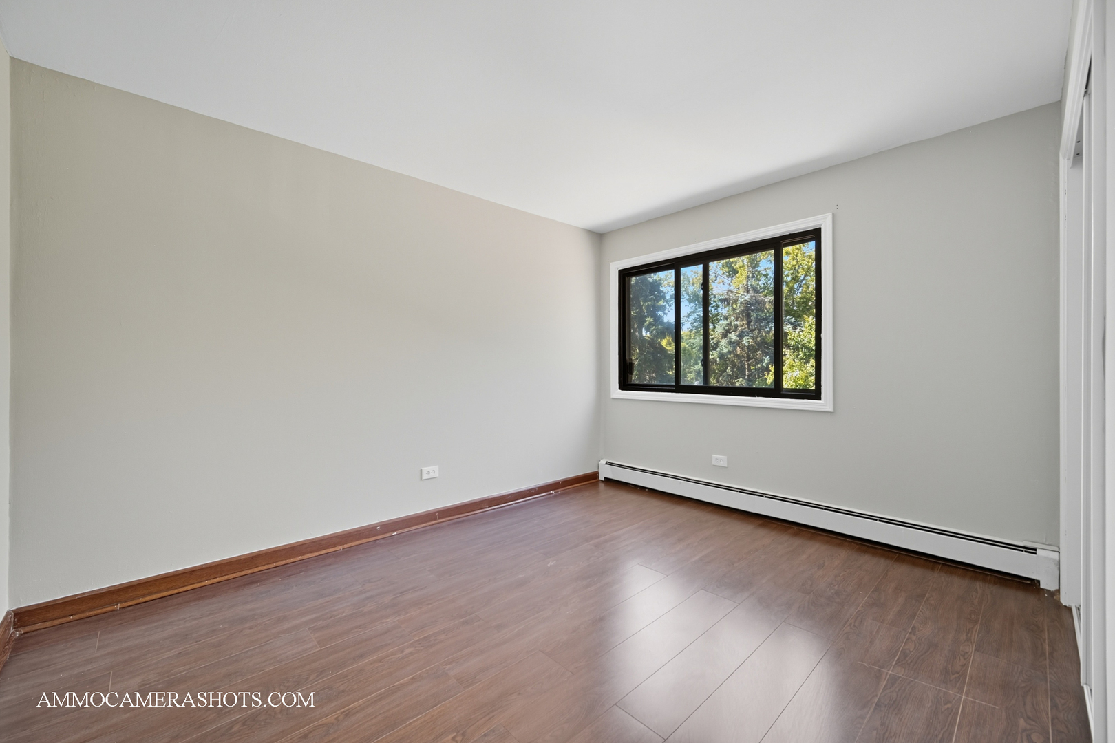 1240 South Lorraine Road, Unit 2D Wheaton, IL 60189 - Photo 12 of 19 an empty room with wooden floor and windows