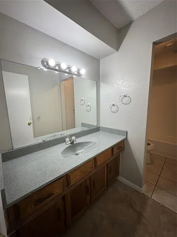 a bathroom with a granite countertop sink a large mirror and a shower