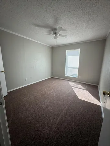 an empty room with a ceiling fan and window