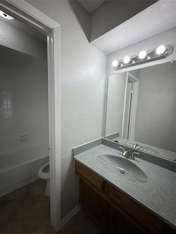 a bathroom with a sink a toilet a shower and a mirror