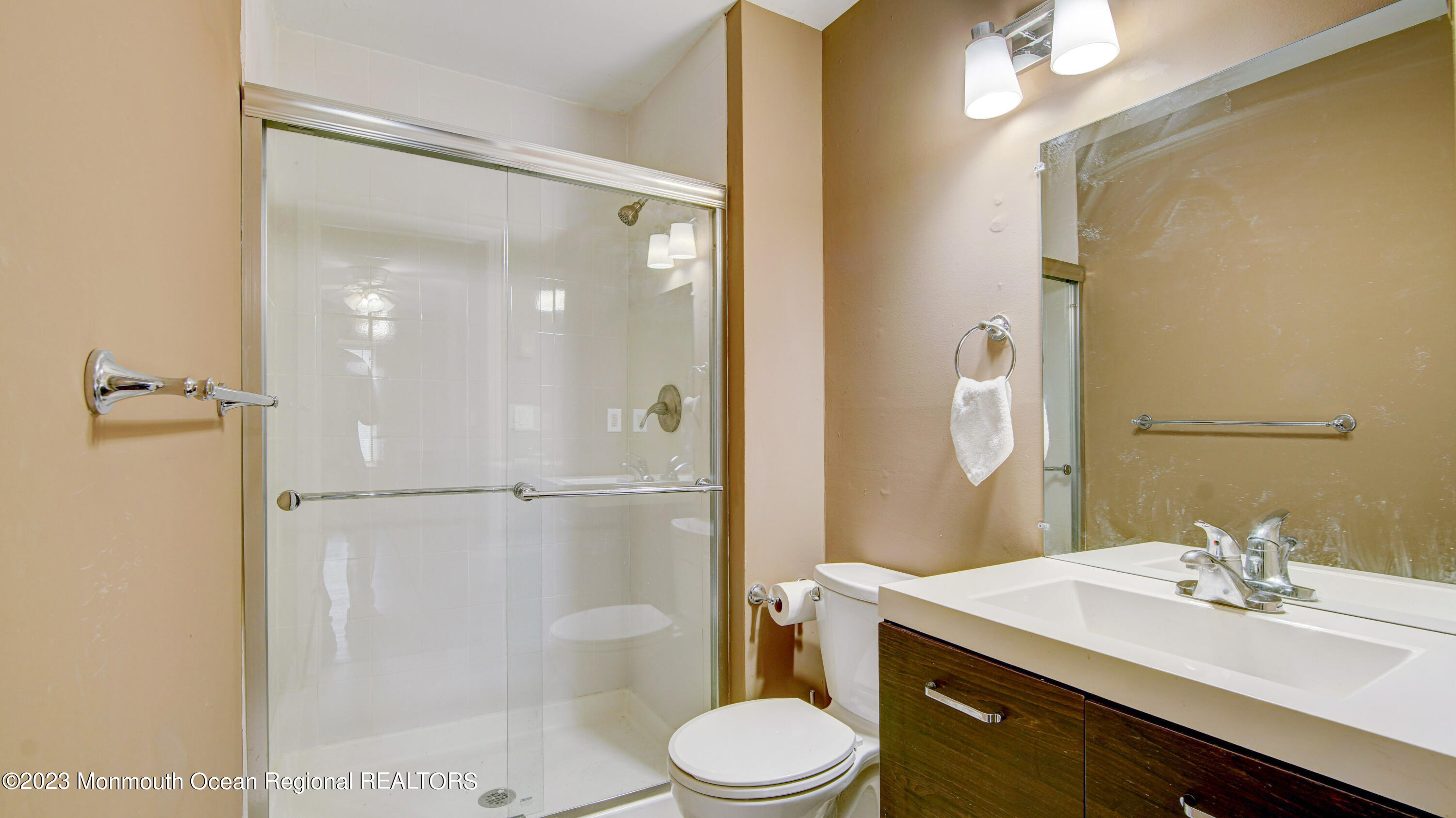 91 Arrowood Road, Unit B Manalapan, NJ 07726 - Photo 12 of 20 a bathroom with a sink toilet a mirror and shower