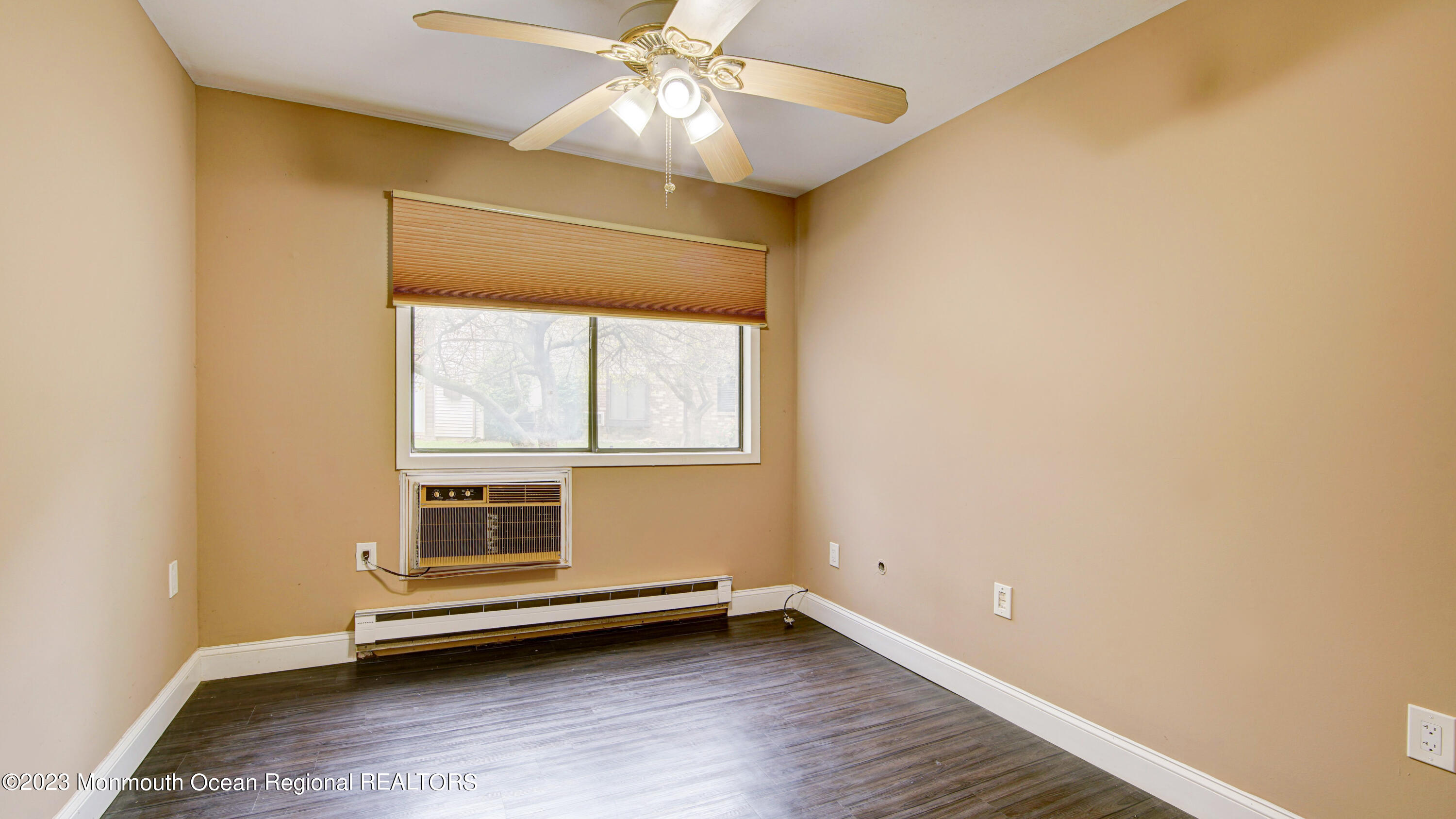 91 Arrowood Road, Unit B Manalapan, NJ 07726 - Photo 14 of 20 a view of an empty room with wooden floor and a window